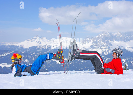 Bruder und Schwester posiert mit ihren Skiern Reiteralm in der Steiermark, im Hintergrund Dachstein Gebirge, Österreich Stockfoto