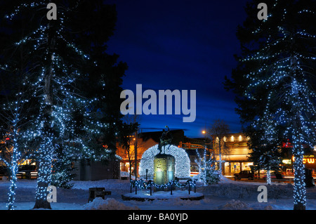 Weihnachtsbeleuchtung Elch Geweih Bögen und Bäume in Jackson Wyoming USA Altstädter Ring im Winter in der Dämmerung mit Cowboy auf bucking Broncho-statue Stockfoto