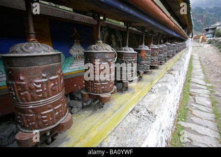 Linie von Gebetsmühlen in einem Dorf auf dem Annapurna trail Stockfoto
