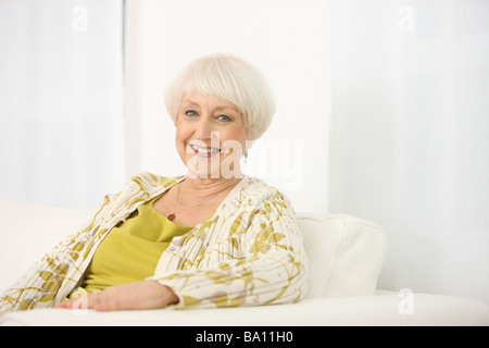 Porträt von senior Frau sitzt auf der couch Stockfoto