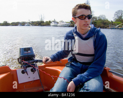 Junger kaukasischer Rüde, der eine Kill Cord trägt, während er ein Motorboot auf dem Fluss Ouse in York steuert. VEREINIGTES KÖNIGREICH Stockfoto