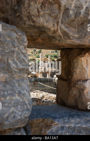 Zeigen Sie auf Domitian Tempel Ruinen in Ephesus durch Loch in Steinmauer, Türkei an. Stockfoto