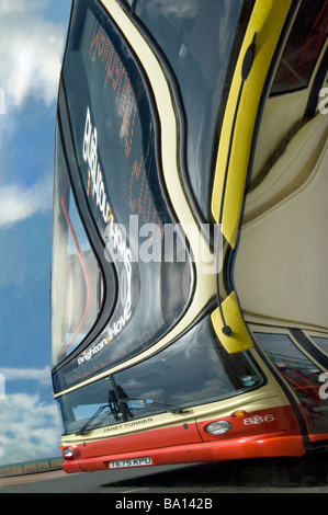 Ein Doppeldecker-Bus spiegelt sich in einer alten Messegelände verzerrenden Spiegel auf Brighton Seafront eine seltsame verzerrte Wirkung verleihen. Stockfoto