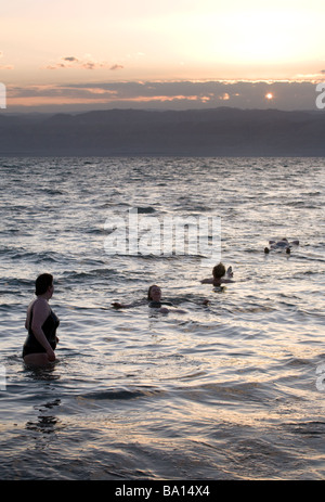 Touristen Schwimmen im Toten Meer bei Sonnenuntergang, Jordanien, Naher Osten Stockfoto