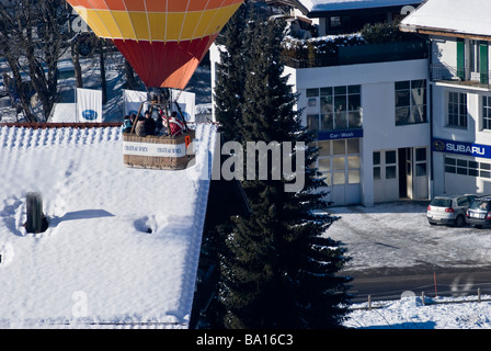Ein Ballon Röcke über Dächer auf der 2009 International Hot Air Balloon Festival Chateau d ' Oex Schweiz. Charles Lupica Stockfoto