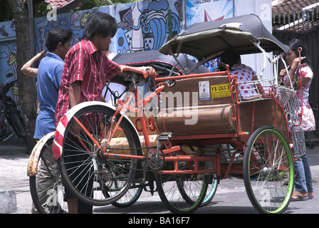 Fahrradrikscha gegen Graffiti-Wand, Yogyakarta, Indonesien.