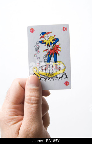 Hand, die Joker Spielkarte vor einem weißen Hintergrund Stockfoto