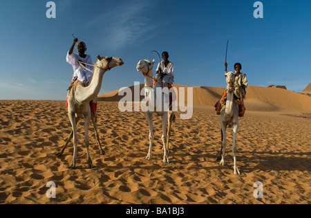 Kamel-Reiter überqueren die Dünen in der Nähe von Merowe-Pyramiden Stockfoto