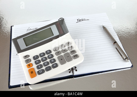Geöffneten Notizbuch mit Stift und Taschenrechner auf reflektierende Oberfläche Stockfoto