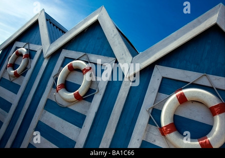 Drei blaue und weiße Strandhütten mit roten und weißen Lebensretter Stockfoto