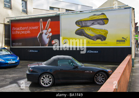 JCDecaux Werbetafeln für Virgin Media Breitband und Puma Trainer auf Privatparkplatz in Cardiff South Wales UK Stockfoto