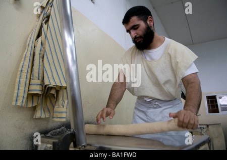 Ein religiöser Jude, der Matzot traditionelles ungesäuertes Brot zubereitete, das auf gegessen wurde Passah in der Kfar Chabad Bäckerei in Zentralisraelisch Stockfoto