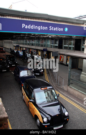 London-Taxis, die Schlange, um Fahrgäste an der Ausfahrt zum Bahnhof Paddington, London, UK zu sammeln. Stockfoto