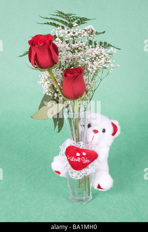 2 rote Rosen in Vase mit einem niedlichen kleine weiße Bären, der sagt "Ich liebe dich" Stockfoto