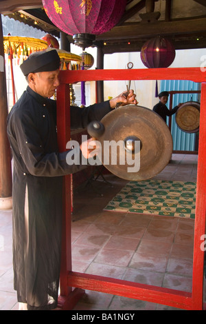 Mönch, ertönt einen Gong an einem Tempel in Hoi An Vietnam Stockfoto