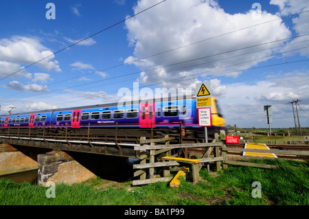 Ein Zug überqueren einen öffentlichen Fußweg "The Ouse Valley Way" an einer Brücke über die Great Ouse in der Nähe von Stretham Cambridgeshire England UK Stockfoto