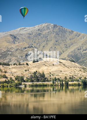 Heißluft-Ballon über See Hayes, Arrowtown, New Zealand, mit der Remarkables im Hintergrund Stockfoto