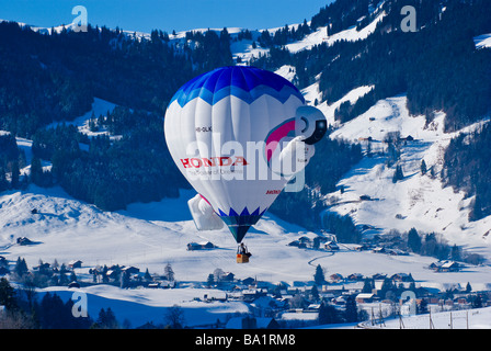 Der Honda-Ballon schwebt 'Azimo' oberhalb des Dorfes; 2009 International Hot Air Balloon Festival Chateau d ' Oex, Schweiz. Stockfoto