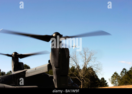 Ein CV-22 Osprey bereitet auszuziehen, als eine a-10 Thunderbolt II über Kopf fliegt. Stockfoto