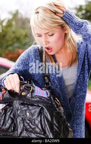 Frau in ihrer Tasche für ihre Geldbörse oder Handy-Suche Stockfoto