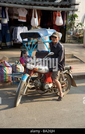 Motorrad Tuk Tuk Fahrer warten auf eine Fahrkarte in der Nacht Markt von Luang Prabang Laos Stockfoto