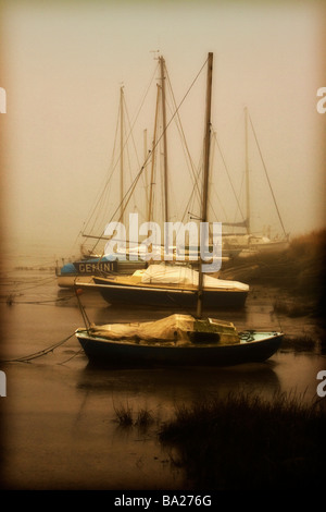 Segelboote, die auf einer Schlammbank mit den Gezeiten, im Nebel gestrandet Stockfoto