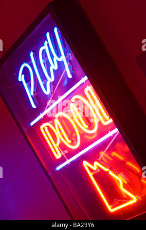 Ein Neonschild mit der Aufschrift "Spielen Pool" am Eingang eine Kellerbar Stockfoto
