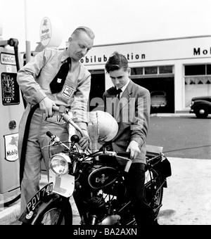 1950s, an den Zapfsäulen, füllt ein uniformierte männliche Mobilgas-Servicedienstler den Kraftstofftank eines jungen Mann-Eagle-Motorrads, England, Großbritannien. Stockfoto