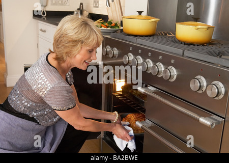 Frau, die Speisen aus dem Ofen Stockfoto