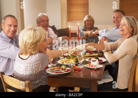 Freunde ziehen Christmas Cracker bei einer Dinner-Party Stockfoto