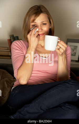 Frau mit Tasse Kaffee vor dem Fernseher entspannen Stockfoto