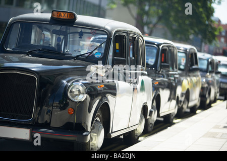 London-Taxis aufgereiht auf Bürgersteig Stockfoto