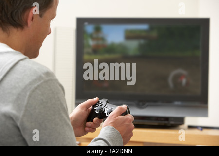 Mann spielt mit Spielkonsole Stockfoto