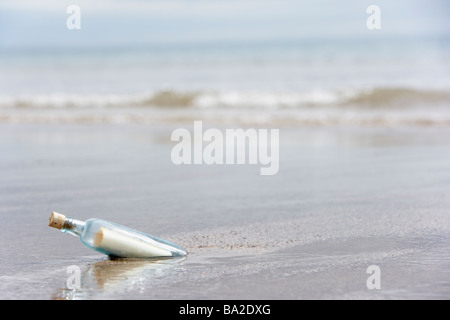 Message In A Bottle vergraben im Sand am Strand Stockfoto