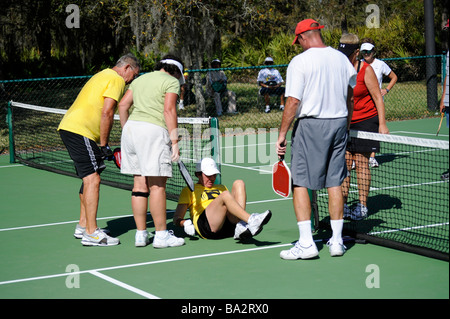 Seniorinnen und Senioren in Pickleball im leitenden Zustand Olympics in der Nähe von Naples, Florida-Spiel verletzt Stockfoto