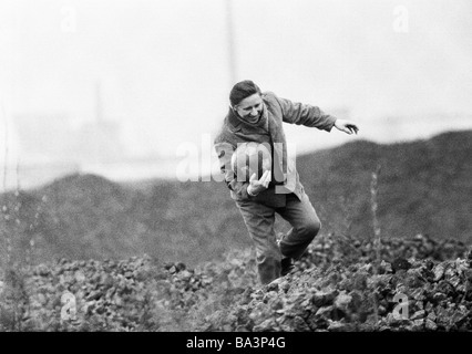 70er Jahre, schwarz / weiß Foto, Menschen, unbeabsichtigt, die ein Fußball, in einem Haufen Mann klettert über den Haufen und holt den Ball gekickt wurde bringen sie wieder auf dem Fußballplatz, Fußballspiel, Humor, im Alter von 35 bis 45 Jahre, Ruhrgebiet, Nordrhein-Westfalen Stockfoto