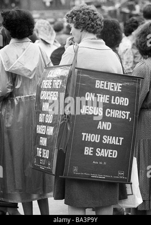 70er Jahre, schwarz / weiß Foto, Menschen auf einer Friedensdemonstration, junge Frau präsentiert ein Schild mit einem Spruch aus der Bibel, im Alter von 30 bis 40 Jahre, Großbritannien, England, London Stockfoto