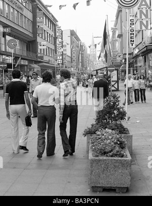 70er Jahre, schwarz / weiß Foto, Menschen auf Einkaufsbummel, drei junge Männer im Alter von 25 bis 30 Jahre, shopping street, Fußgänger Zone, Bahnhof Street, im Hintergrund die evangelische Stadtkirche, D-Gelsenkirchen, Ruhrgebiet, Nordrhein-Westfalen Stockfoto