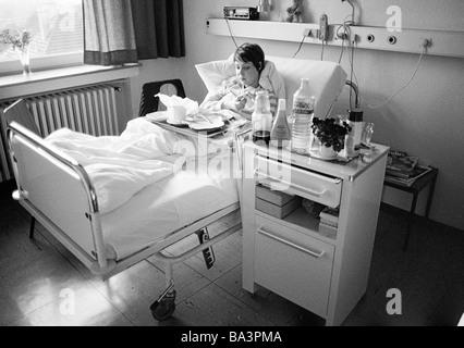 Achtziger Jahre, schwarz / weiß Foto, Menschen, Gesundheit, junge Frau in einem Krankenhaus, Abendessen in einem Krankenbett, im Alter von 25 bis 30 Jahren, Monika Stockfoto