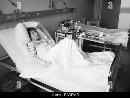 Achtziger Jahre, schwarz / weiß Foto, Menschen, Gesundheit, junge Frau liegt in einem Krankenbett eines Krankenhauses, im Alter von 25 bis 30 Jahren, Monika Stockfoto
