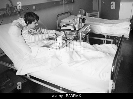 Achtziger Jahre, schwarz / weiß Foto, Menschen, Gesundheit, junge Frau in einem Krankenhaus, Abendessen in einem Krankenbett, im Alter von 25 bis 30 Jahren, Monika Stockfoto