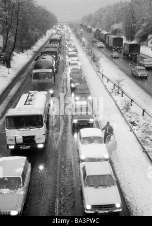 70er Jahre, schwarz / weiß Foto, Straßenverkehr, Stau auf der Autobahn A2 in der Nähe von Oberhausen, Twilight, Winter, Schnee, Matsch, Autos fahren auf gedimmten Scheinwerfern, D-Oberhausen, D-Oberhausen-Sterkrade, Ruhrgebiet, Nordrhein-Westfalen Stockfoto