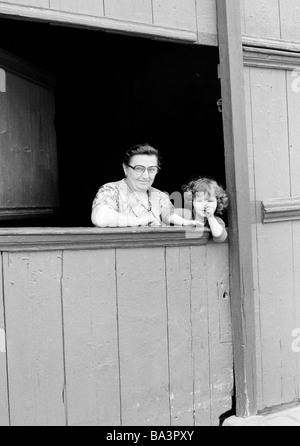 Der achtziger Jahre, schwarz / weiß Foto, Menschen, ältere Frau und ihre Enkelin Blick aus einer stabilen, im Alter von 60 bis 70 Jahren, im Alter von 3 bis 4 Jahre Stockfoto