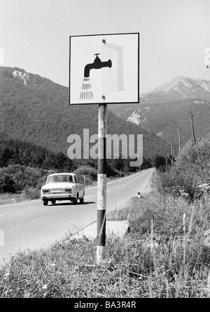 Der siebziger Jahre, schwarz / weiß Foto, Auto fährt auf einer Landstraße durch das Velebit-Gebirge, ein Schild am Straßenrand führt zu den nächsten Rastplatz mit waschen Option, Kroatien, damals Jugoslawien, Jugoslawien Stockfoto