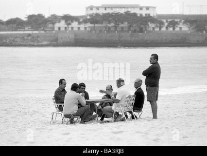 Achtziger Jahre, schwarz / weiß Foto, Menschen, mehrere Männer sitzen an einem Tisch am Strand von Copacabana und Karten spielen, im Alter von 50 bis 70 Jahre, Brasilien, Rio De Janeiro Stockfoto