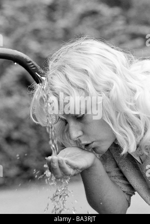 Achtziger Jahre, Menschen, Junge Frau entschied Wasser von Einems Brunnen, Erfrischung, Abkuehlung, Portraet, Blondhaarig, Elisabeth Stockfoto