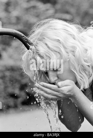 Achtziger Jahre, Menschen, Junge Frau entschied Wasser von Einems Brunnen, Erfrischung, Abkuehlung, Portraet, Blondhaarig, Elisabeth Stockfoto