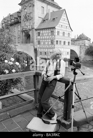 Achtziger Jahre, schwarz / weiß Foto, Beruf, Fotograf bei der Arbeit, warten auf richtige Beleuchtung, Kamera, Stativ, Kamera Reisetasche, Frau, im Alter von 30 bis 35 Jahre, Elisabeth, im Hintergrund das historische Rathaus Bamberg, Barock, Brücke, Regnitz Bridge, Fachwerkhaus, UNESCO-Weltkulturerbe, D-Bamberg, Regnitz, Main-Donau-Kanal, Franken, Bayern Stockfoto