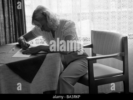 Achtziger Jahre, schwarz / weiß Foto, Menschen, junge Frau sitzt an einem Tisch schreiben einen Brief, Gegenlicht, Dämmerung, im Alter von 25 bis 35 Jahre, Elisabeth Stockfoto
