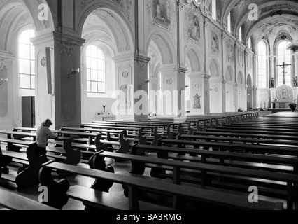 Achtziger Jahre, schwarz / weiß Foto, Religion, Christentum, junge Frau in eine Kirchenbank kniet und betet, im Alter von 30 bis 35 Jahre, Elisabeth Stockfoto